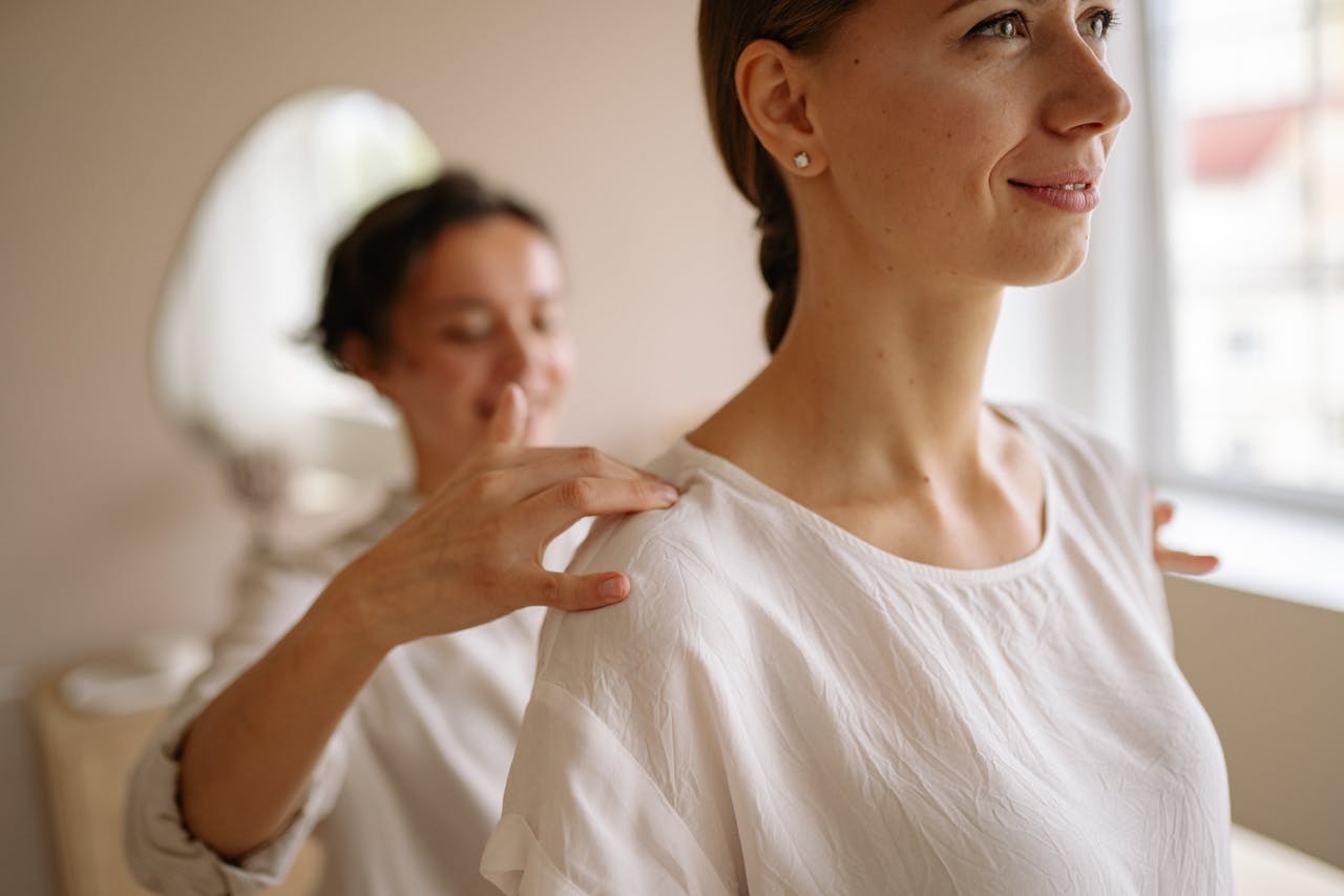 A satisfied client smiles after a neuromuscular therapy session, demonstrating restored mobility and pain relief.