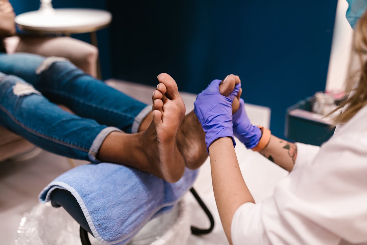 Close-up of a massage therapist's hands on a client’s foot during a reflexology foot massage.